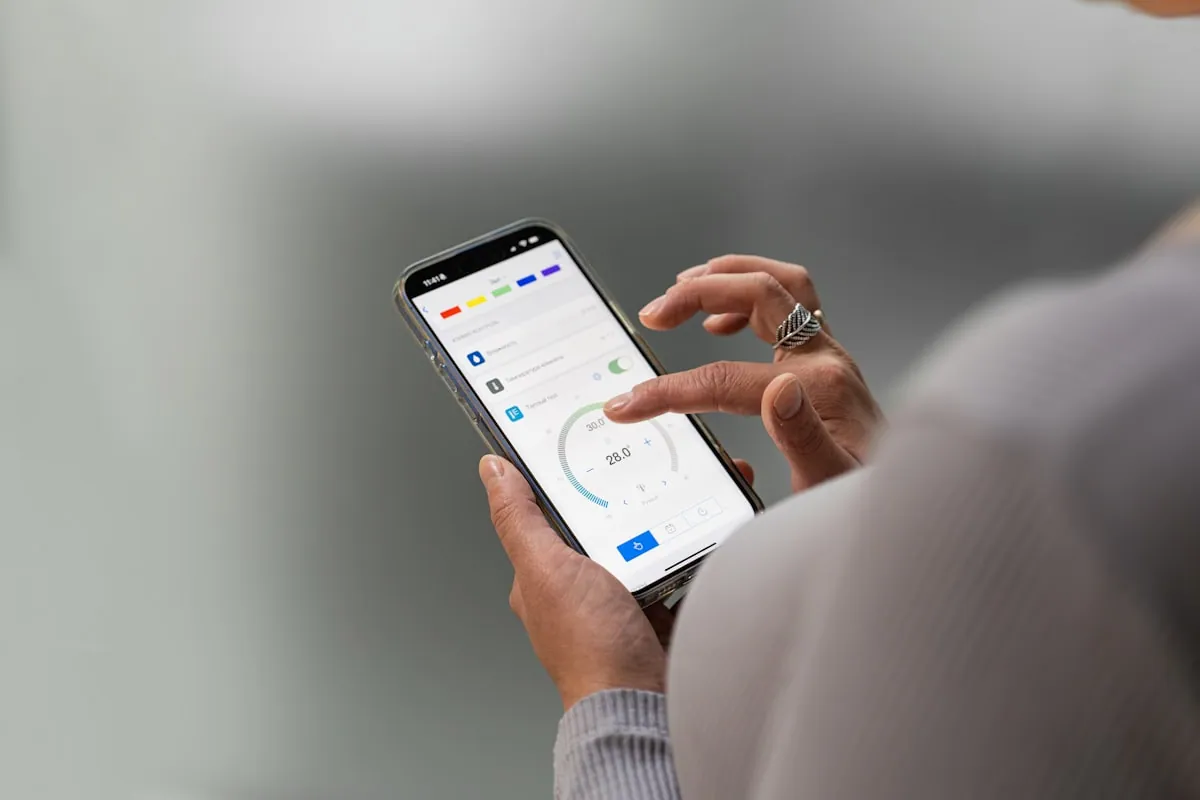 Hånd som holder en mobiltelefon med bankapp sett ovenfra