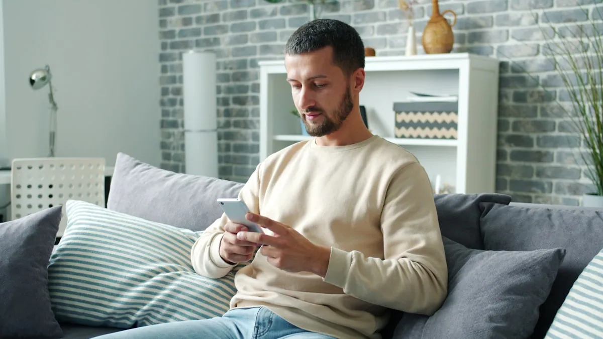 Person i sofaen som ser på mobilskjermen