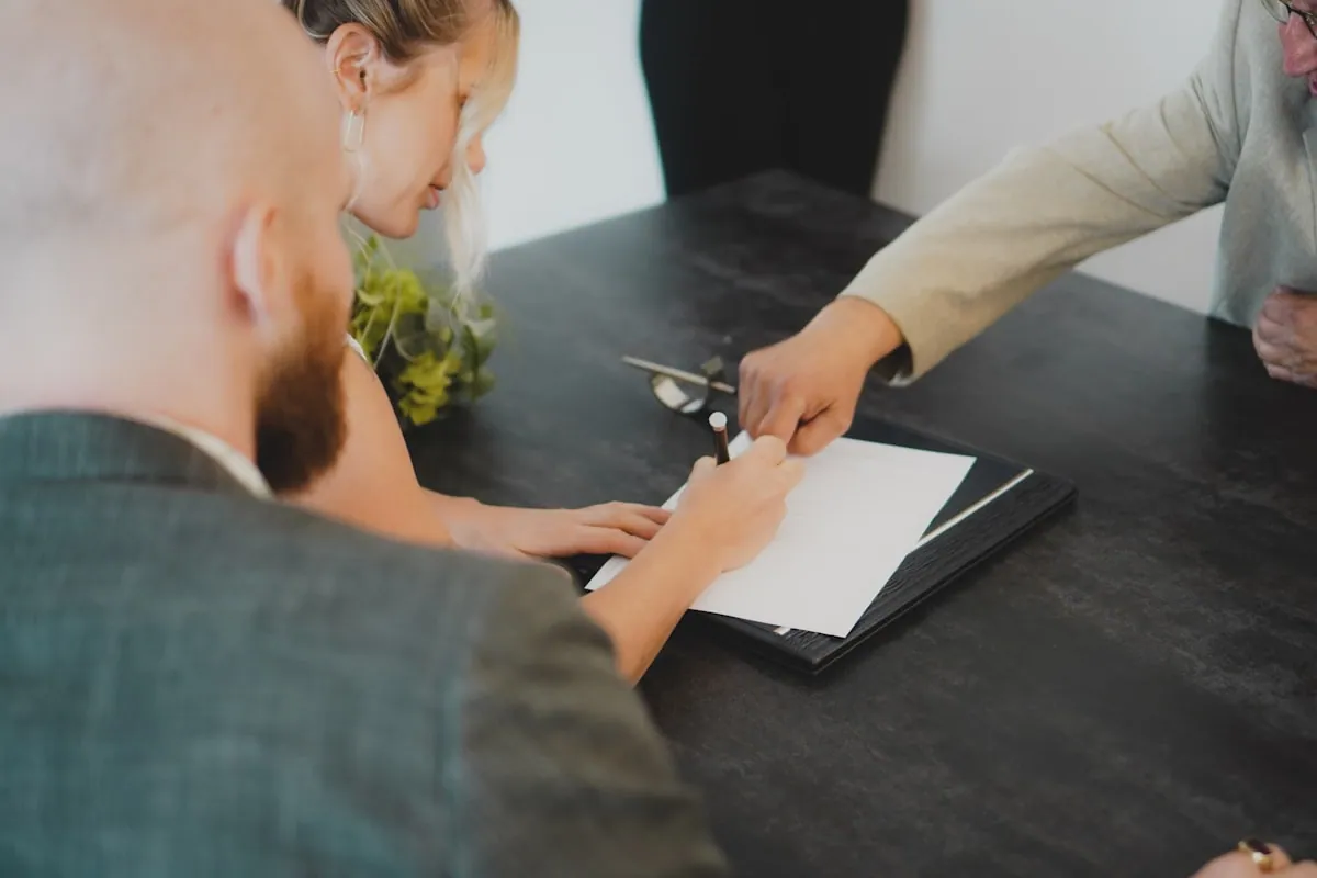 To personer som går gjennom dokumenter og signerer i dagslys